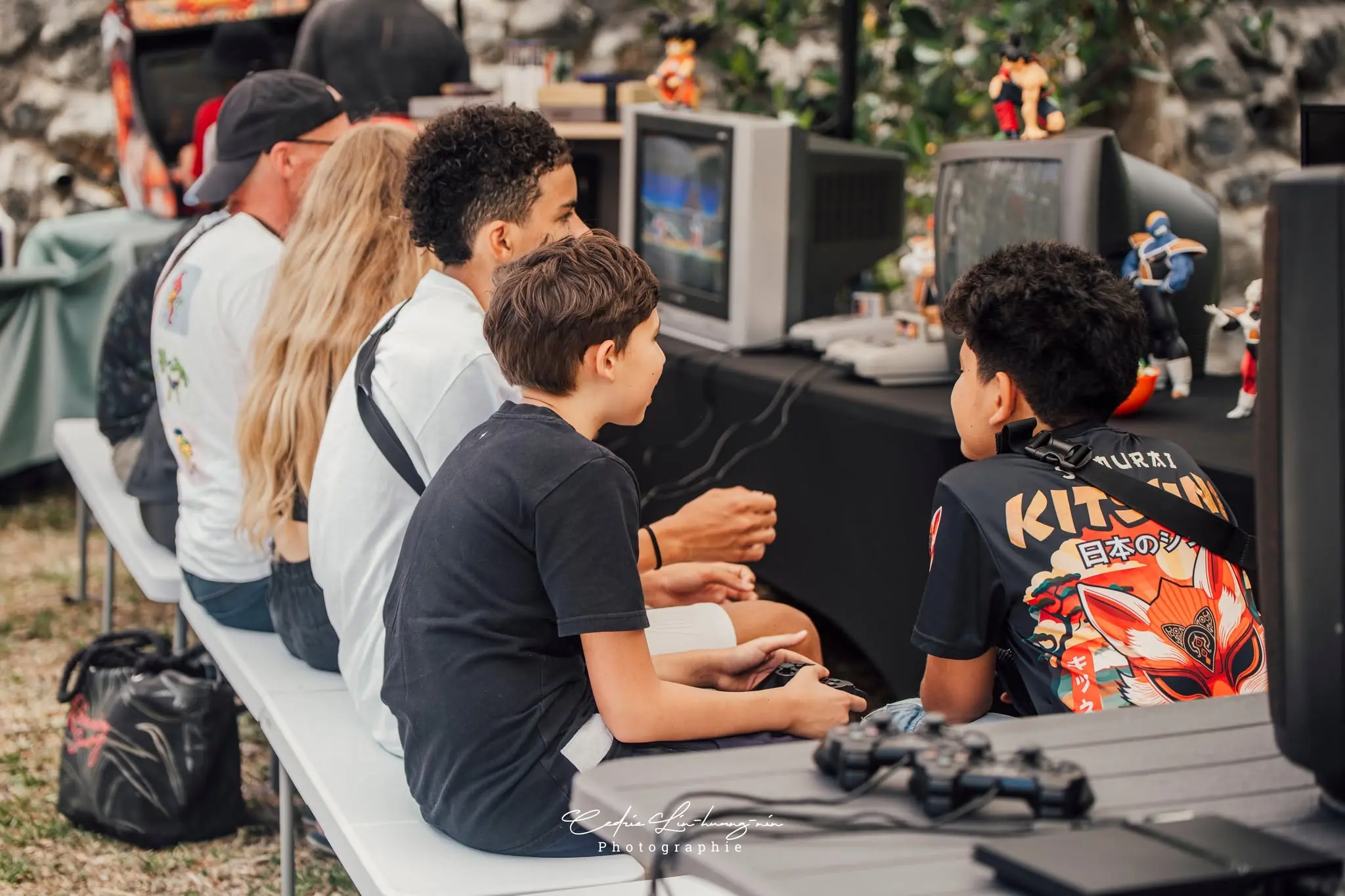 Des joueurs sont réunis autour de consoles rétro et de téléviseurs cathodiques