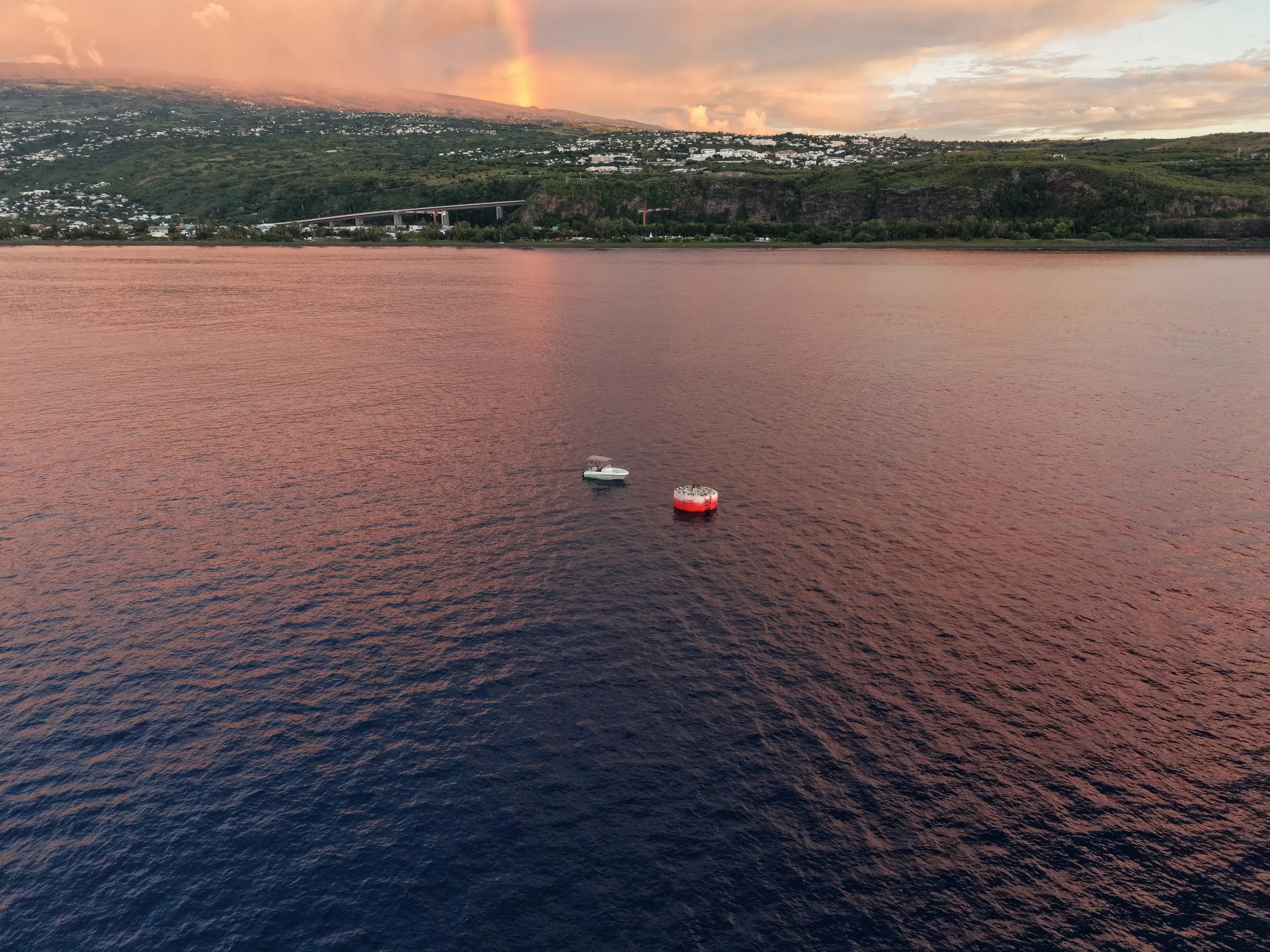 Aerial view of a bay on Reunion Island and boats at sunset.
