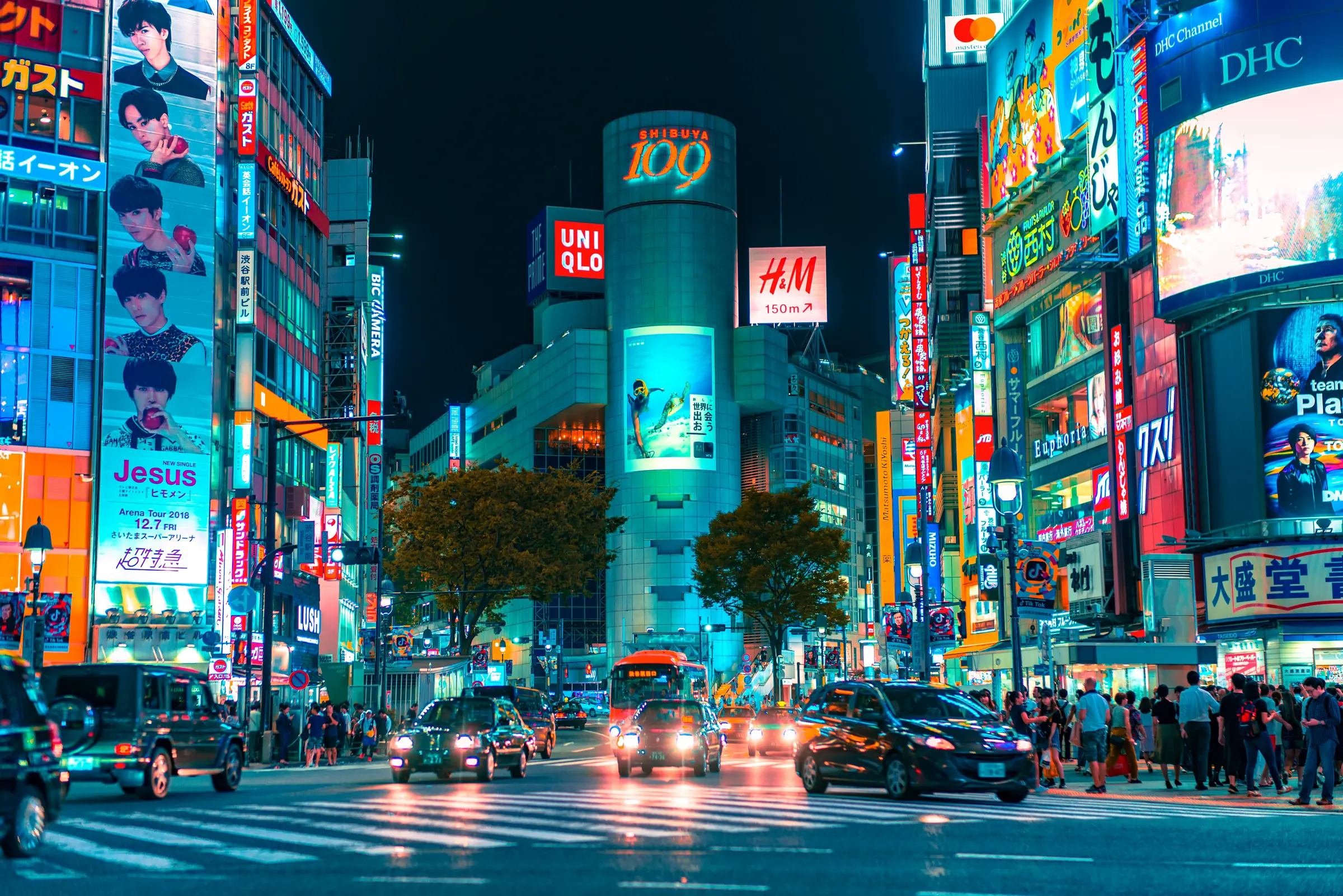 Un grand carrefour de Tokyo illuminé par les écrans et les enseignes nocturnes