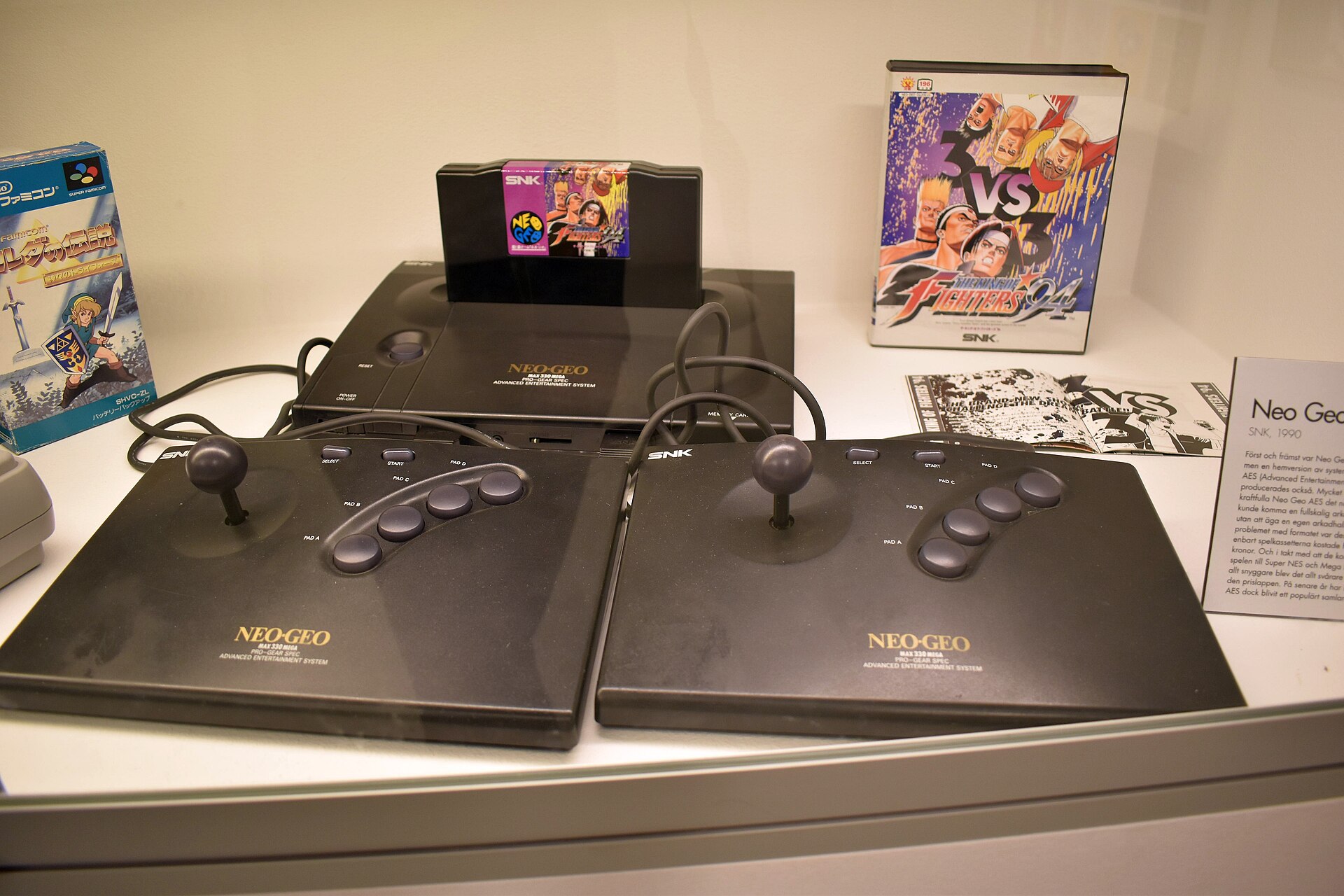 Neo Geo AES exposée avec une cartouche et une boîte japonaise de The King of Fighters 94